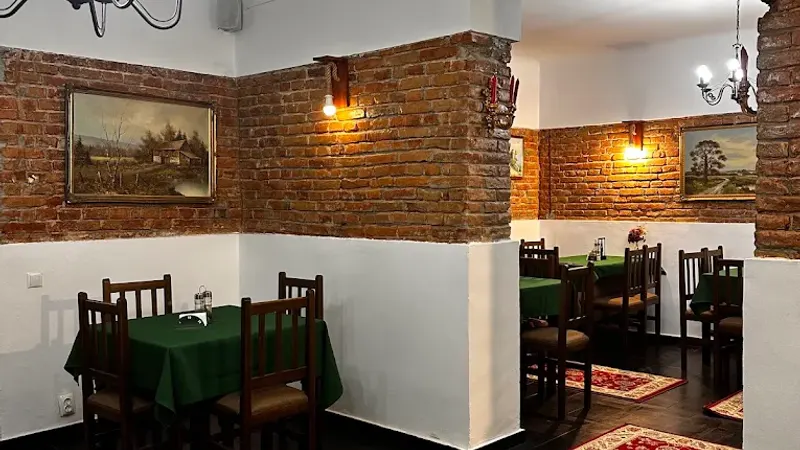 Salonul restaurantului Ciorbe La Ion, cu mese de lemn și pereți de cărămidă